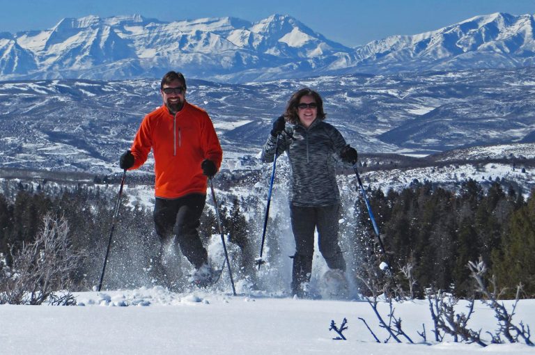 Two people snowshoeing in mountains