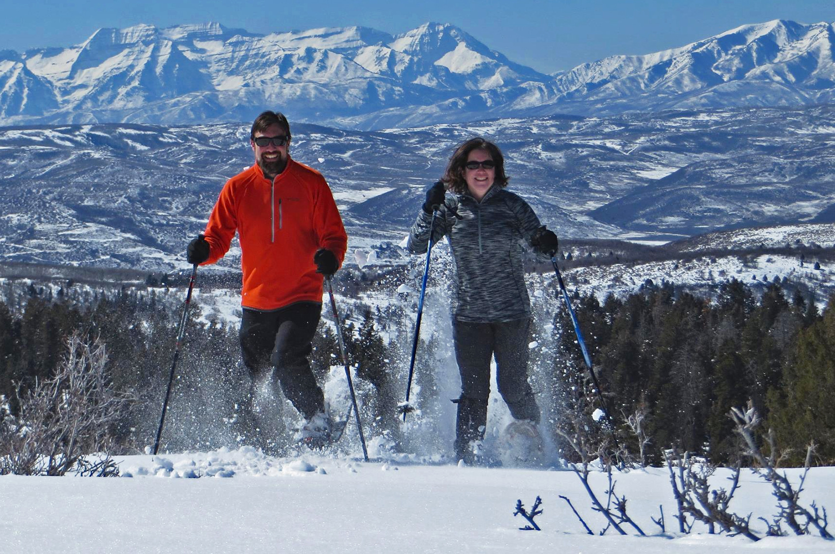Two people snowshoeing in mountains