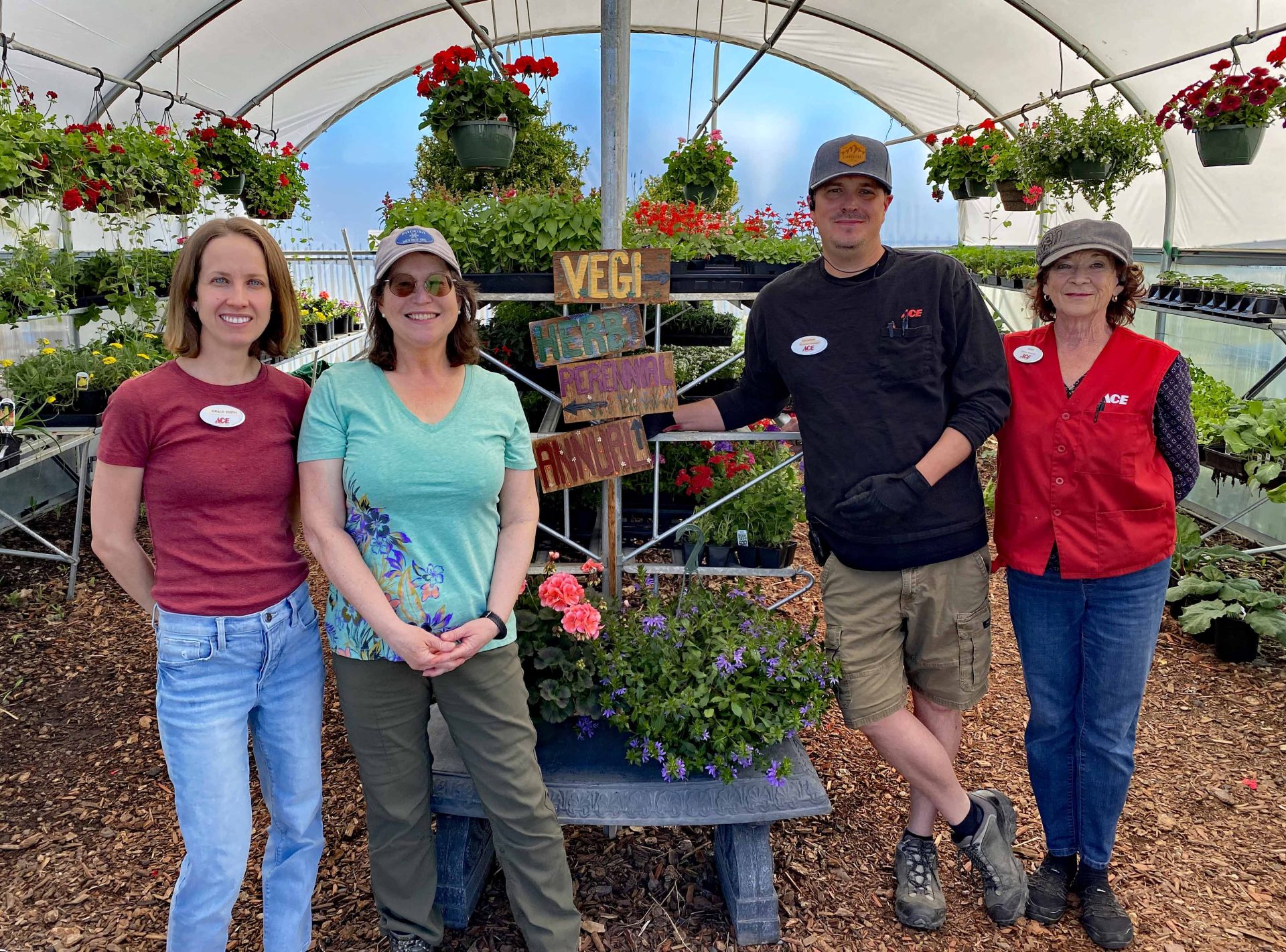 4 people standing in green house.