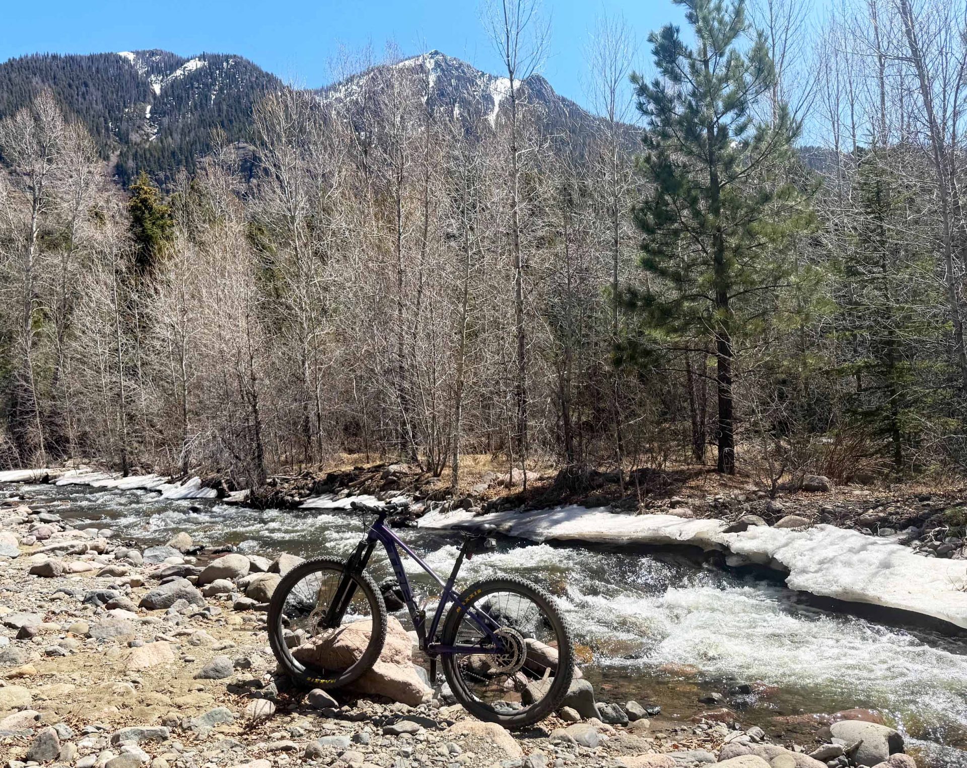 Bike resting against rocks next to a stream